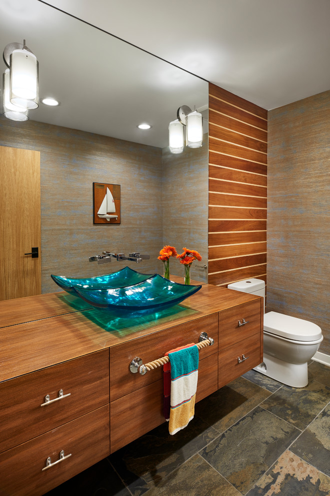 Photo of a mid-sized beach style powder room in Minneapolis with flat-panel cabinets, medium wood cabinets, brown walls, slate floors, a vessel sink, wood benchtops, brown floor and brown benchtops.