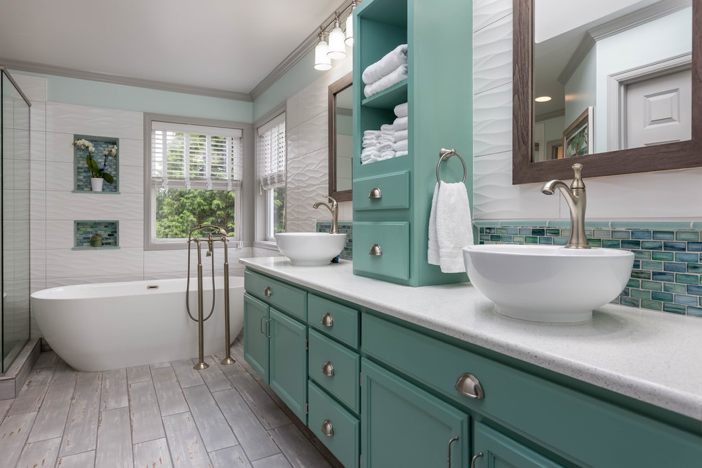 Inspiration for a large transitional master bathroom in Seattle with turquoise cabinets, a freestanding tub, white tile, glass tile, engineered quartz benchtops, a hinged shower door, a corner shower, white walls, porcelain floors, a vessel sink, grey floor and recessed-panel cabinets.