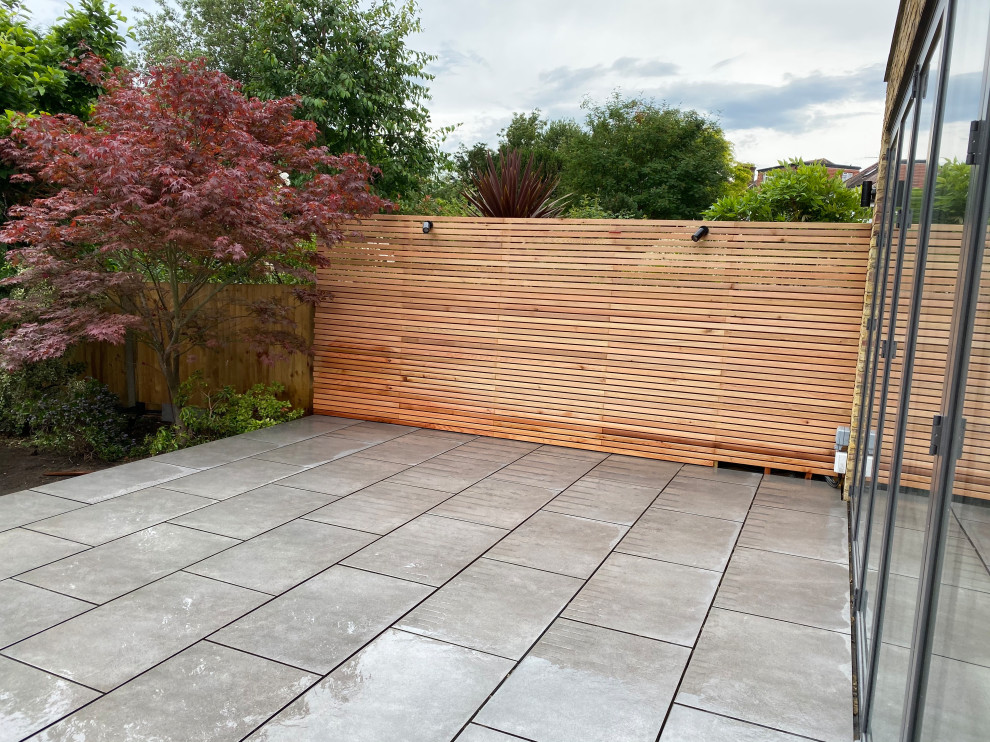 Immagine di un giardino design esposto in pieno sole di medie dimensioni e dietro casa in primavera con recinzione in legno