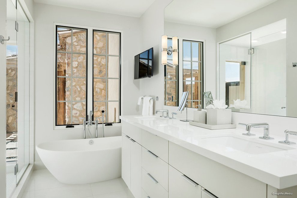 Example of a mid-sized trendy master white floor freestanding bathtub design in Phoenix with flat-panel cabinets, white cabinets, white walls, an undermount sink and quartzite countertops