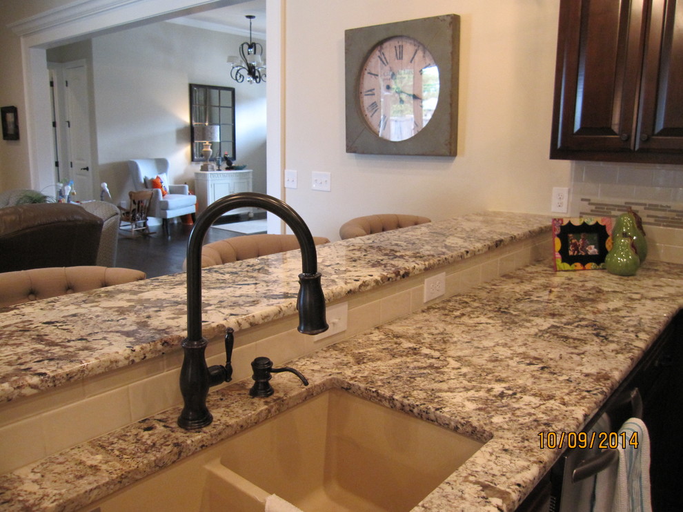 Inspiration for a large transitional galley dark wood floor eat-in kitchen remodel with an undermount sink, raised-panel cabinets, dark wood cabinets, granite countertops, multicolored backsplash, ceramic backsplash, stainless steel appliances and an island