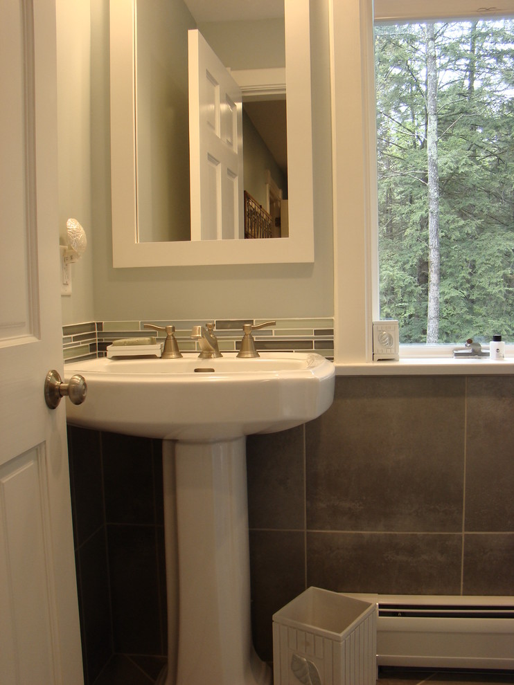 Photo of a small contemporary 3/4 bathroom in Portland Maine with a pedestal sink, a curbless shower, a wall-mount toilet, gray tile, glass tile, blue walls and porcelain floors.