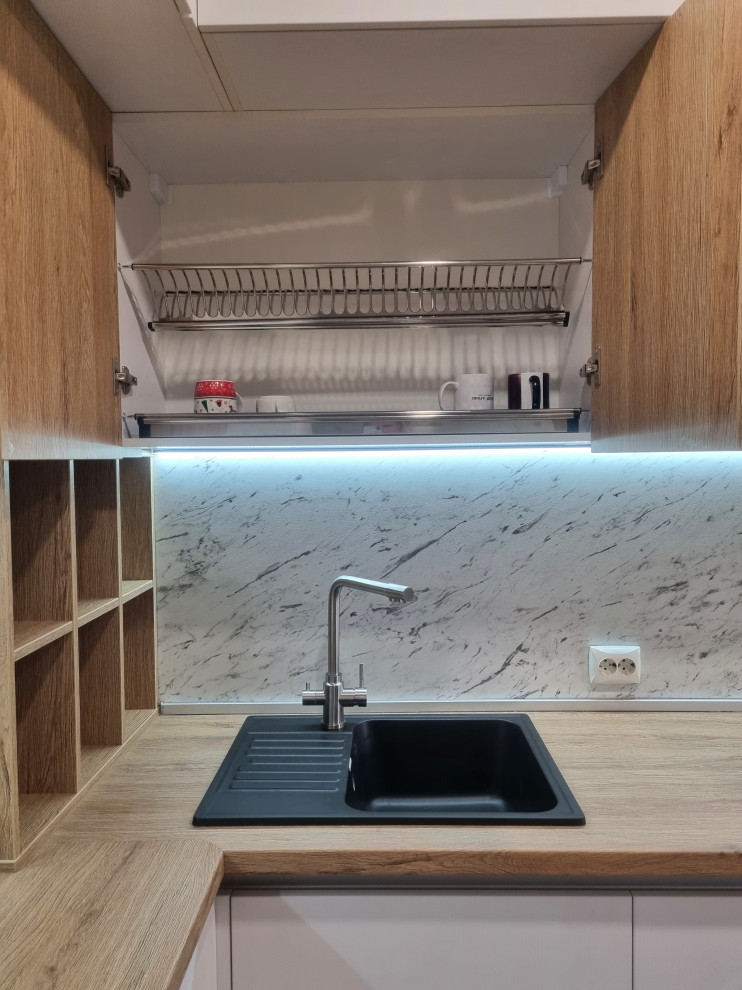 Foto på ett mellanstort minimalistiskt kök, med en nedsänkt diskho, laminatbänkskiva och integrerade vitvaror