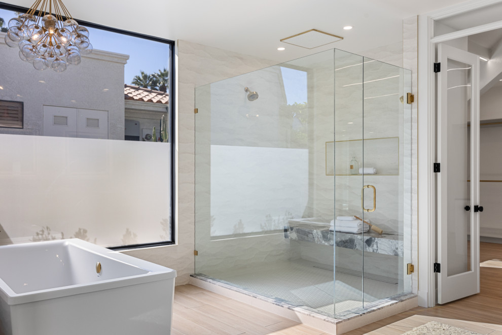 Freestanding bathtub - large transitional master white tile and ceramic tile porcelain tile, beige floor and double-sink freestanding bathtub idea with flat-panel cabinets, medium tone wood cabinets, a one-piece toilet, white walls, an integrated sink, marble countertops, a hinged shower door, gray countertops and a floating vanity