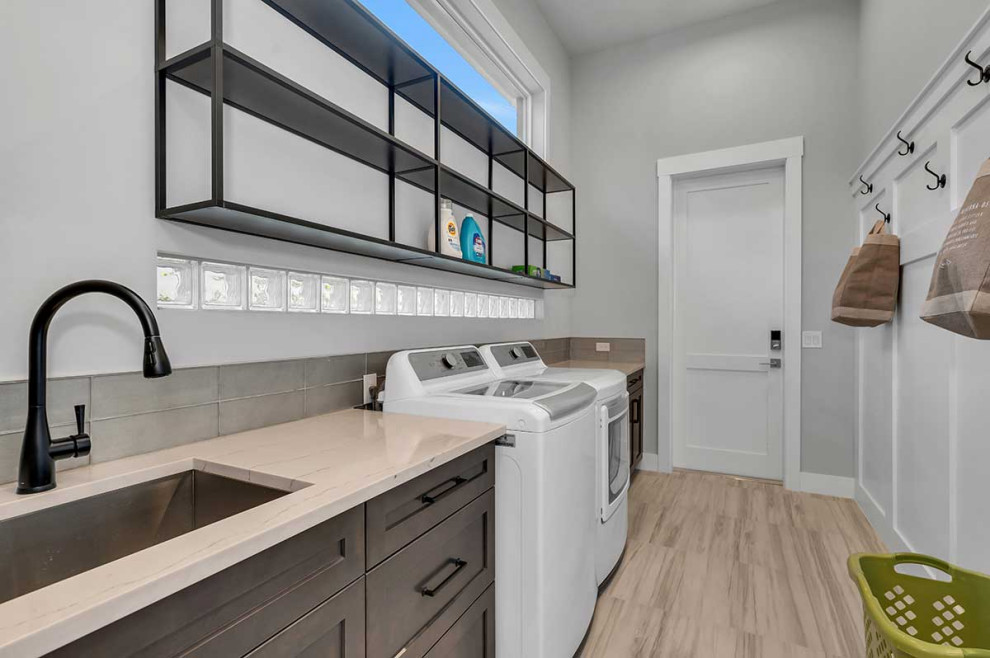 Photo of a large contemporary galley utility room in Miami with an undermount sink, shaker cabinets, medium wood cabinets, quartz benchtops, grey splashback, grey walls, porcelain floors, a side-by-side washer and dryer, beige floor and beige benchtop.