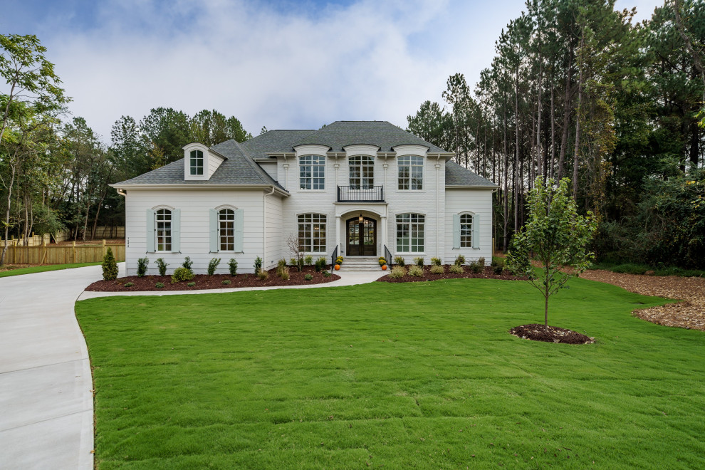 Photo of an expansive traditional two-storey white house exterior in Raleigh with a hip roof and a shingle roof.