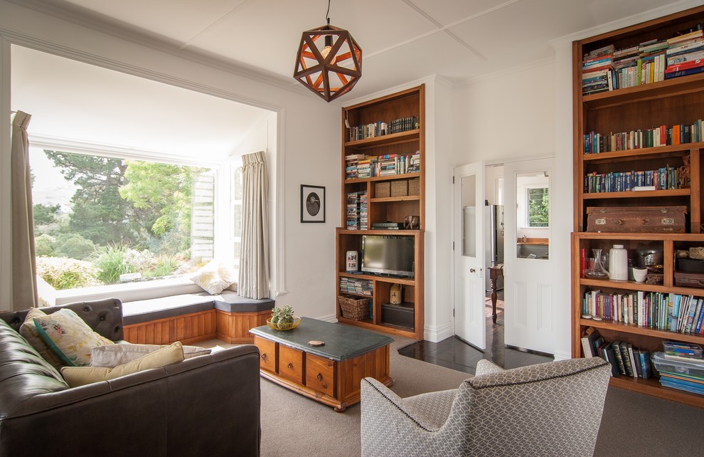 Photo of a traditional Enclosed living room in Auckland With a Library, White Walls, Carpet, a Freestanding TV and Grey Floor.