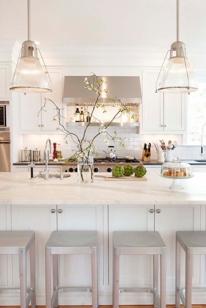 Design ideas for a traditional kitchen in New York with stainless steel appliances, marble benchtops, recessed-panel cabinets, white cabinets, white splashback, subway tile splashback and white benchtop.