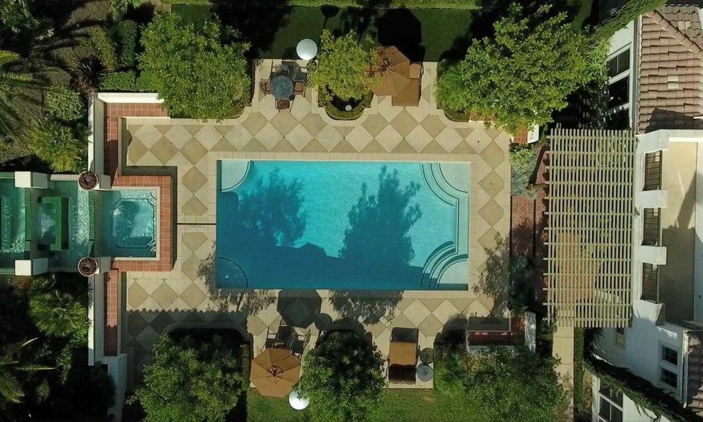 This is an example of a large mediterranean backyard full sun formal garden for summer in Los Angeles with a water feature and natural stone pavers.