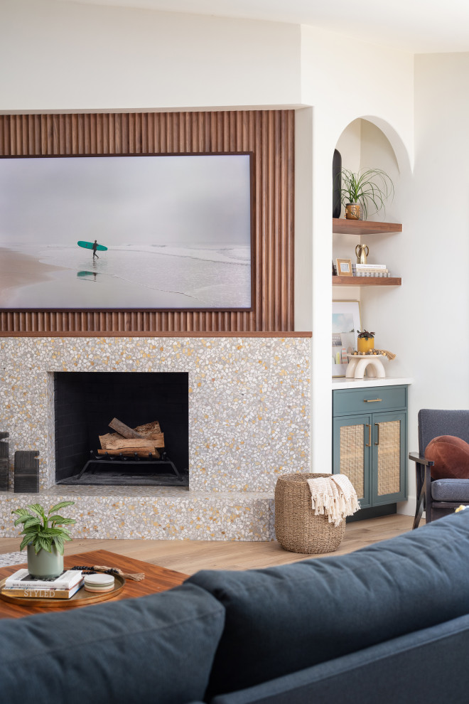 Photo of a large beach style living room in San Diego with white walls, light hardwood flooring, a standard fireplace, a concrete fireplace surround, a wall mounted tv and panelled walls.