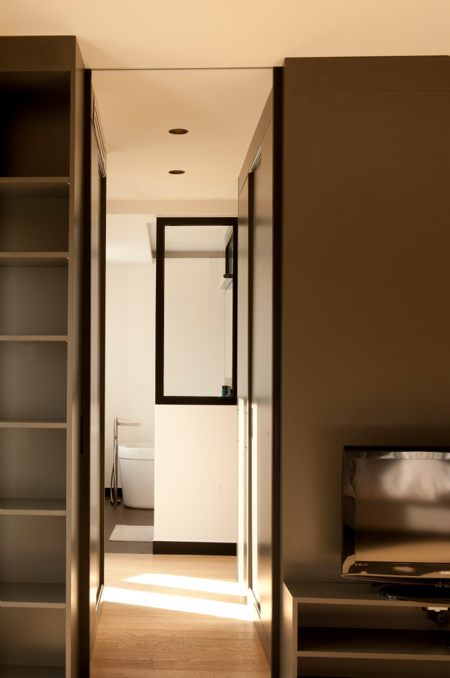 Exemple d'une grande chambre parentale tendance avec un mur beige, parquet clair, un sol beige, un plafond décaissé et dressing.
