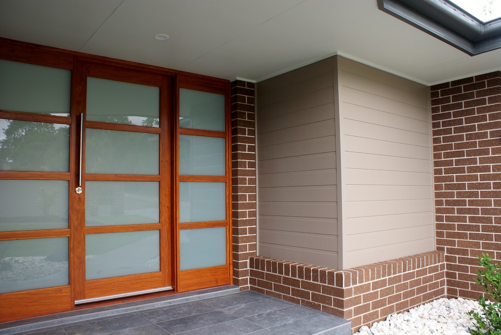 Photo of a mid-sized modern one-storey brick brown exterior in Sydney.