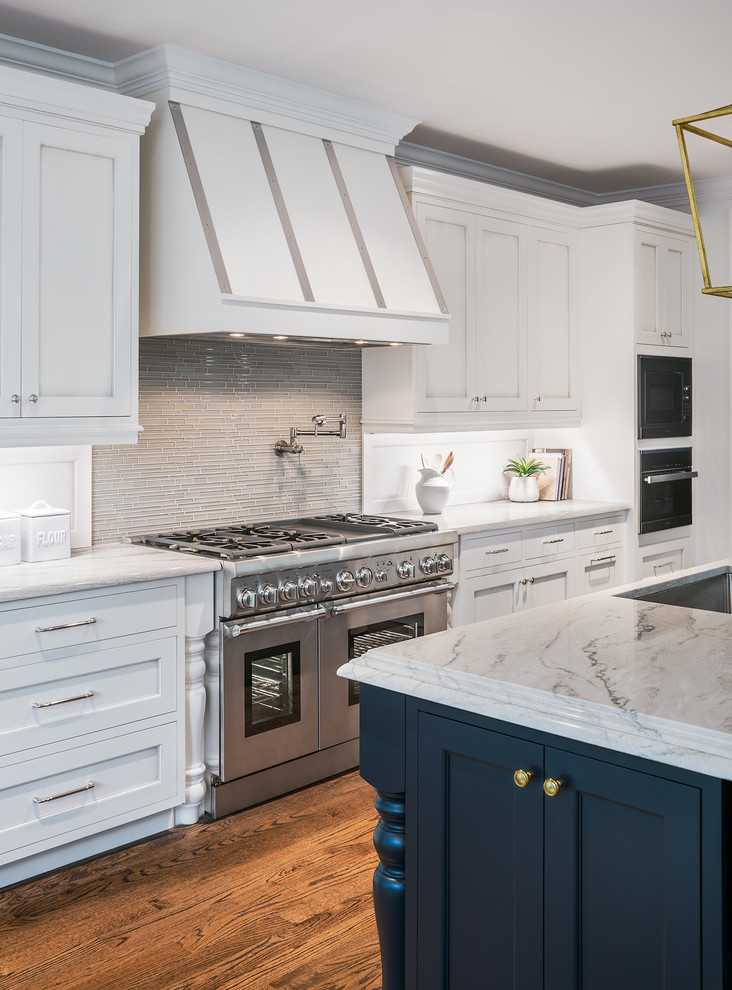 Design ideas for a mid-sized transitional l-shaped open plan kitchen in DC Metro with an undermount sink, beaded inset cabinets, white cabinets, quartzite benchtops, green splashback, glass tile splashback, stainless steel appliances, dark hardwood floors, with island and brown floor.
