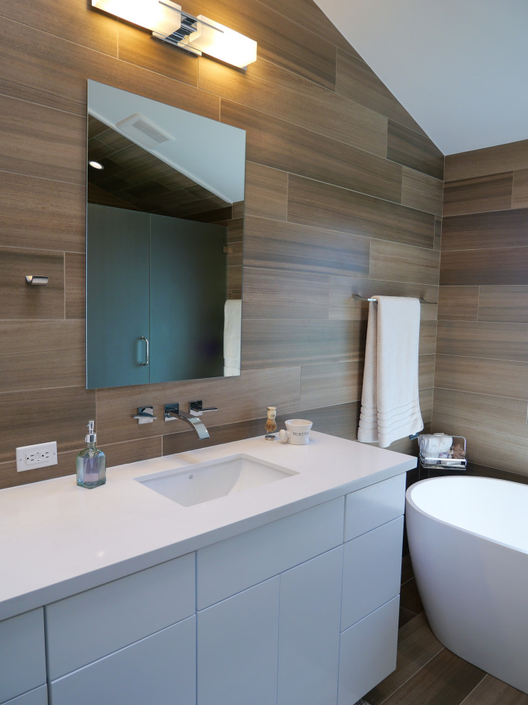 Design ideas for a mid-sized modern master bathroom in Los Angeles with flat-panel cabinets, white cabinets, a freestanding tub, an alcove shower, a one-piece toilet, brown tile, brown walls, an undermount sink, quartzite benchtops, brown floor, a hinged shower door, white benchtops, an enclosed toilet, a double vanity, a built-in vanity, wood walls, porcelain tile and porcelain floors.