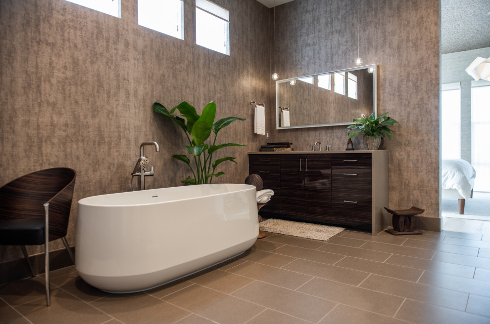 Photo of a mid-sized contemporary master bathroom in Denver with dark wood cabinets, a freestanding tub, a double shower, beige walls, light hardwood floors, beige floor, a hinged shower door, an enclosed toilet, a double vanity, a built-in vanity and wallpaper.