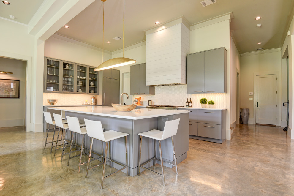 Open concept kitchen - mid-sized transitional l-shaped open concept kitchen idea in New Orleans with a farmhouse sink, flat-panel cabinets, gray cabinets, paneled appliances and an island