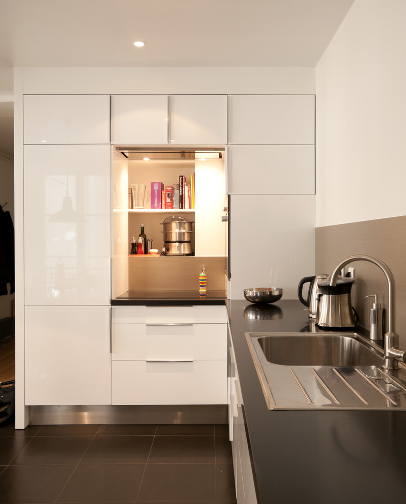 Photo of a mid-sized contemporary l-shaped separate kitchen in Paris with a drop-in sink, flat-panel cabinets, white cabinets, grey splashback and no island.