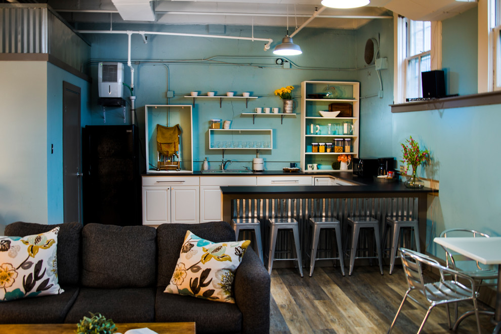 Mid-sized transitional u-shaped medium tone wood floor and brown floor enclosed kitchen photo in Indianapolis with blue walls, no fireplace, a drop-in sink, open cabinets, white cabinets, quartz countertops, black appliances and a peninsula