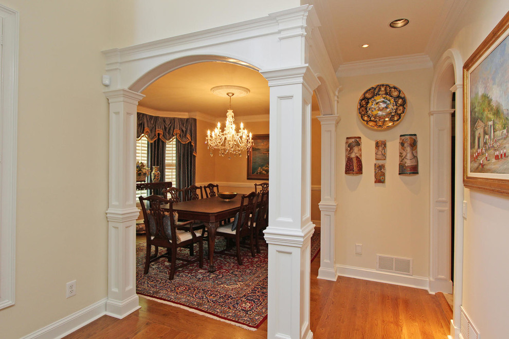 Inspiration for a large traditional separate dining room in Atlanta with yellow walls, medium hardwood floors, no fireplace and brown floor.