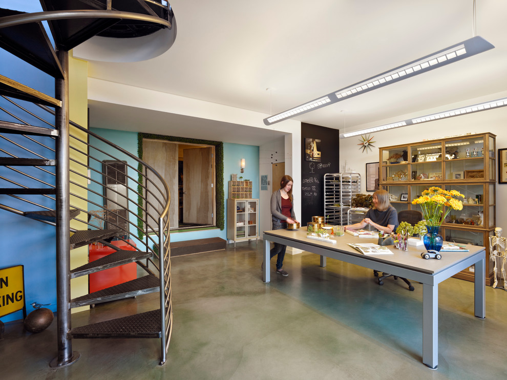 This is an example of an eclectic home studio in San Francisco with multi-coloured walls, concrete floors, no fireplace and a freestanding desk.