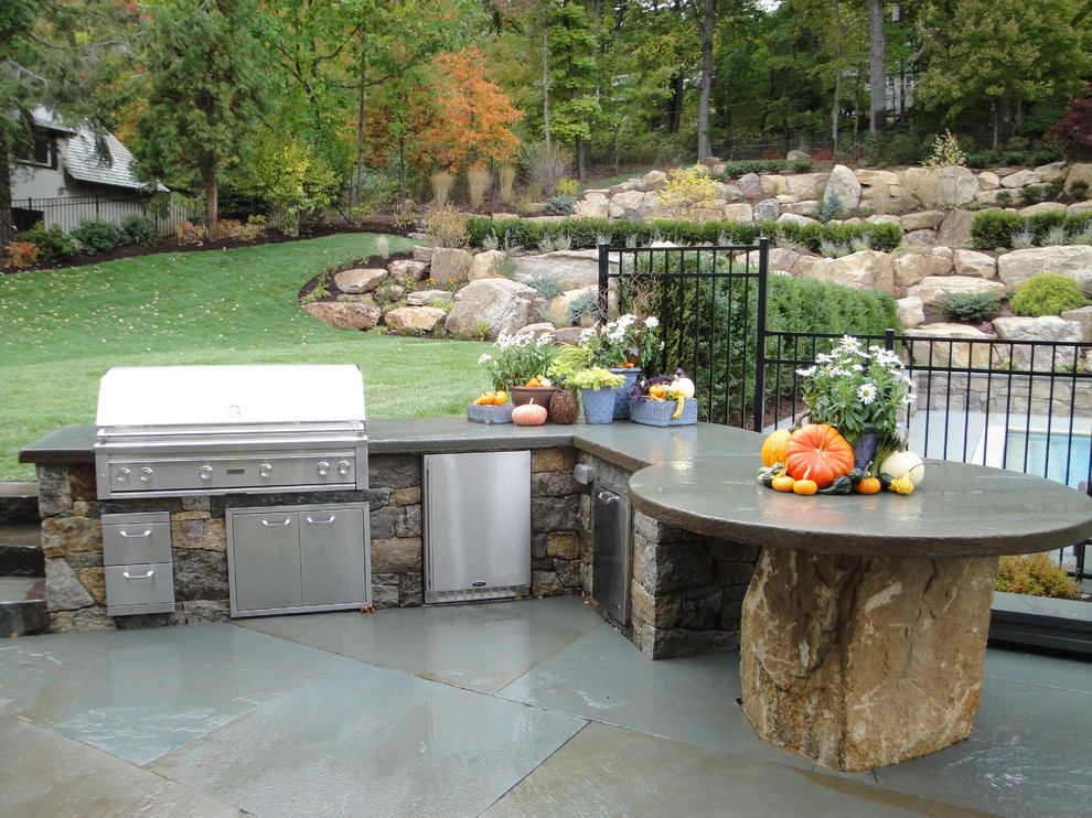 Photo of a mid-sized traditional backyard patio in New York with no cover and natural stone pavers.