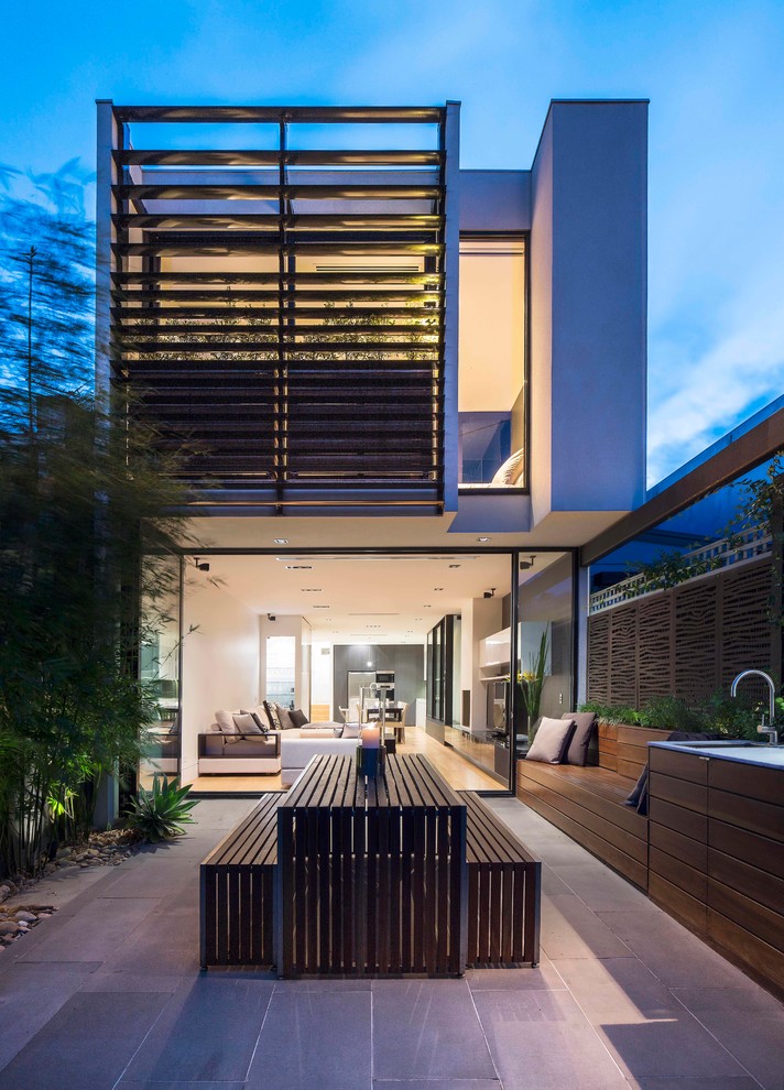 Photo of a large contemporary two-storey exterior in Melbourne with mixed siding and a flat roof.