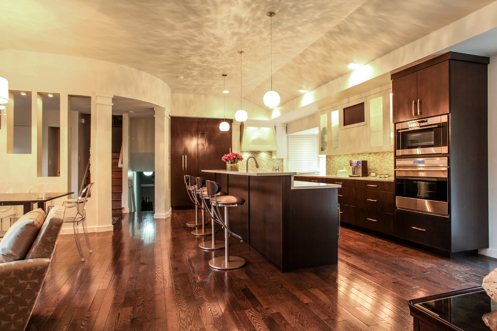 Eat-in kitchen - large modern u-shaped dark wood floor eat-in kitchen idea in Indianapolis with an undermount sink, flat-panel cabinets, dark wood cabinets, quartz countertops, green backsplash, glass tile backsplash, stainless steel appliances and an island