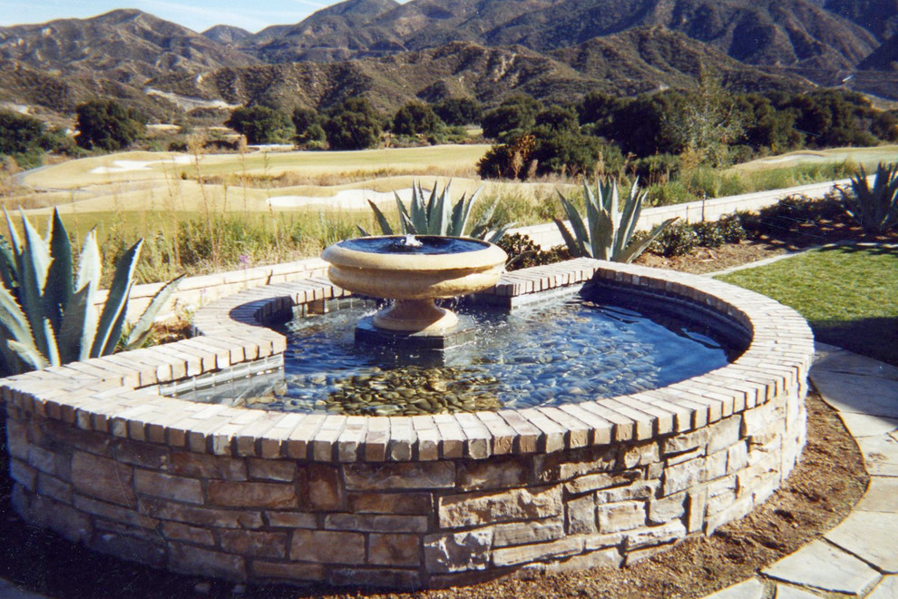 Mid-sized country backyard partial sun formal garden in Orange County with a water feature and brick pavers.