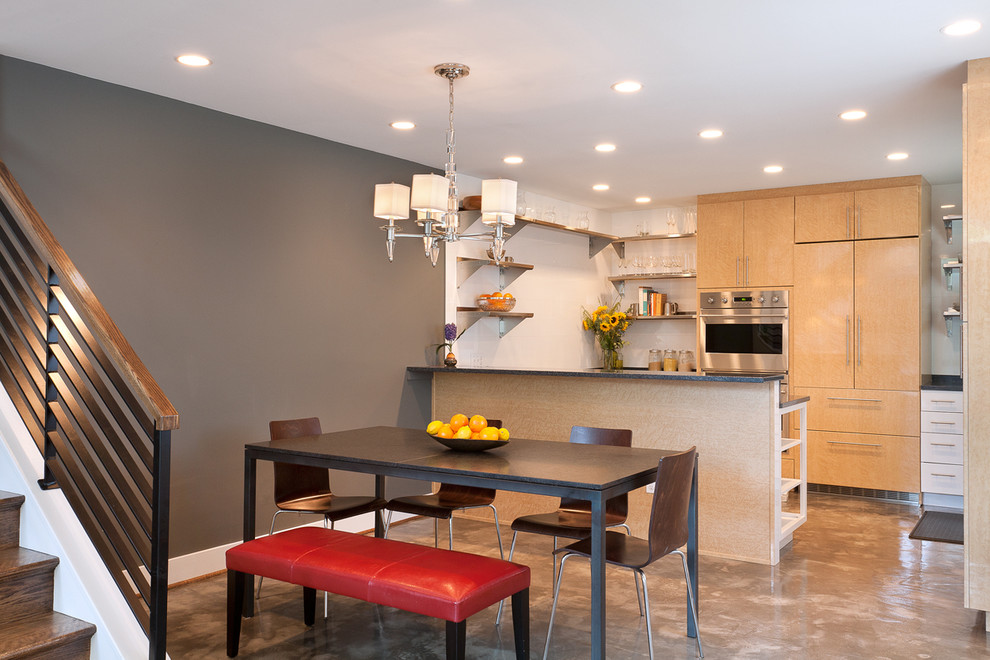 Small eclectic galley eat-in kitchen in DC Metro with flat-panel cabinets, light wood cabinets, a double-bowl sink, soapstone benchtops, panelled appliances, concrete floors, a peninsula and grey floor.