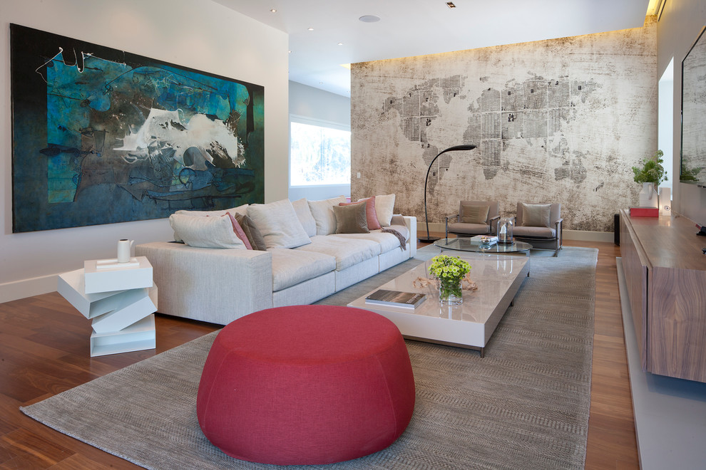 Photo of a contemporary open concept family room in Mexico City with beige walls, medium hardwood floors, a wall-mounted tv and beige floor.