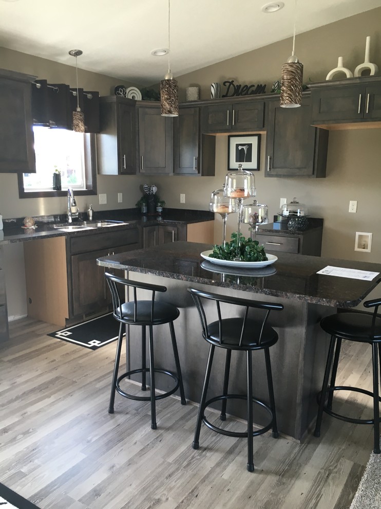 This is an example of a modern l-shaped kitchen in Other with shaker cabinets, with island, a drop-in sink, distressed cabinets, granite benchtops, light hardwood floors and beige floor.