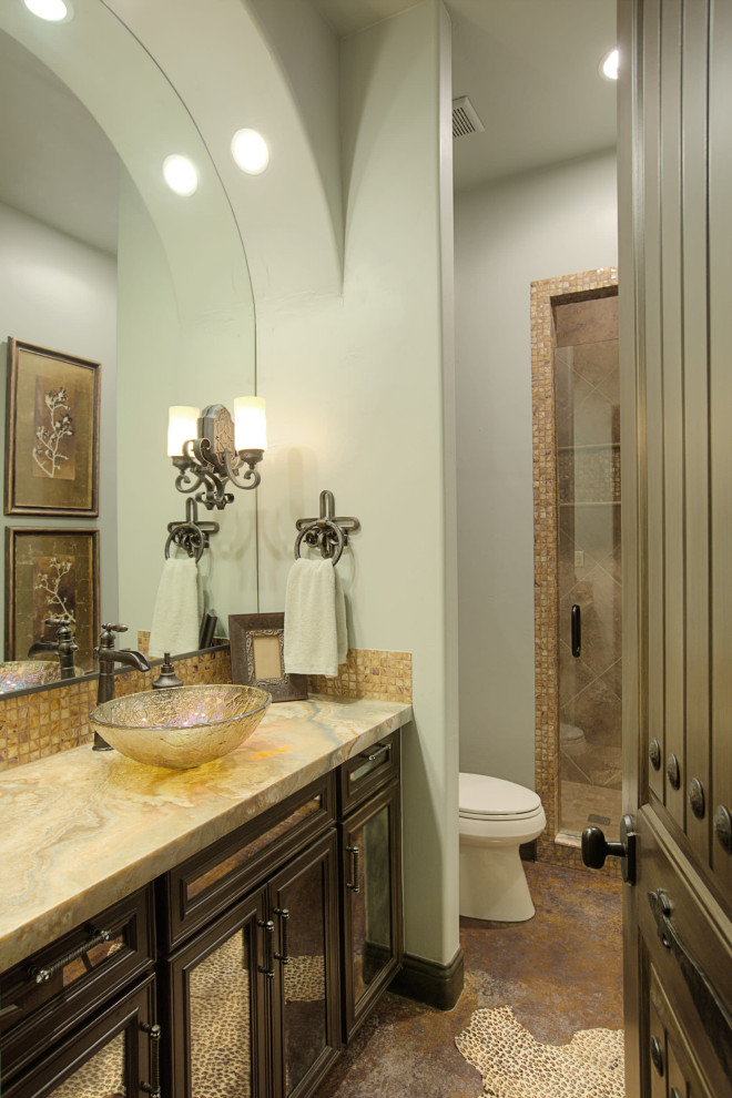 На фото: главная ванная комната в средиземноморском стиле с фасадами с выступающей филенкой, отдельно стоящей ванной, открытым душем, унитазом-моноблоком, бежевой плиткой, плиткой из известняка, зелеными стенами, полом из известняка, врезной раковиной, столешницей из оникса, бежевым полом, открытым душем и желтой столешницей