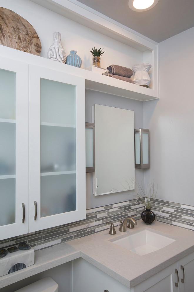 Design ideas for a mid-sized contemporary kids bathroom in Denver with shaker cabinets, white cabinets, an alcove tub, a shower/bathtub combo, a one-piece toilet, white tile, gray tile, grey walls, an undermount sink, engineered quartz benchtops, white floor, a sliding shower screen, matchstick tile and mosaic tile floors.