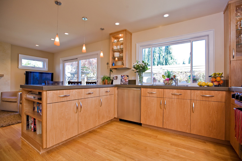 Mid-sized modern u-shaped open plan kitchen in San Francisco with an undermount sink, flat-panel cabinets, medium wood cabinets, concrete benchtops, stainless steel appliances and medium hardwood floors.