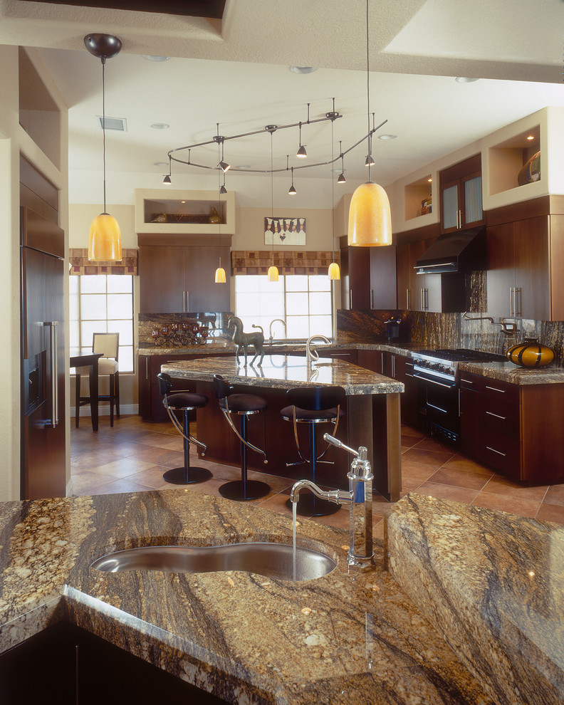 Mid-sized transitional l-shaped eat-in kitchen in San Diego with granite benchtops, an undermount sink, dark wood cabinets, panelled appliances, flat-panel cabinets, multi-coloured splashback, stone slab splashback, terra-cotta floors and beige floor.