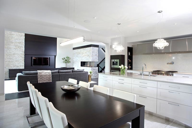 This is an example of an expansive contemporary single-wall open plan kitchen in Toronto with an undermount sink, recessed-panel cabinets, white cabinets, quartz benchtops, mosaic tile splashback, stainless steel appliances, travertine floors, with island and grey splashback.