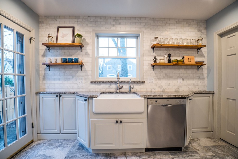 Design ideas for a mid-sized traditional u-shaped eat-in kitchen in Other with a farmhouse sink, raised-panel cabinets, white cabinets, granite benchtops, grey splashback, marble splashback, stainless steel appliances, porcelain floors, a peninsula, grey floor and blue benchtop.