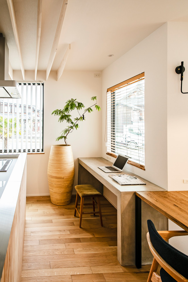 Modernes Arbeitszimmer ohne Kamin mit weißer Wandfarbe, hellem Holzboden, Einbau-Schreibtisch und Tapetendecke in Sonstige