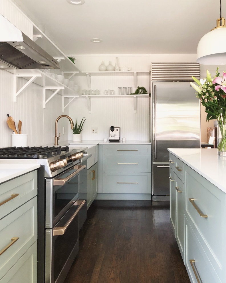 Design ideas for a mid-sized scandinavian kitchen pantry in New York with a farmhouse sink, shaker cabinets, green cabinets, quartz benchtops, white splashback, timber splashback, stainless steel appliances, dark hardwood floors, with island and white benchtop.