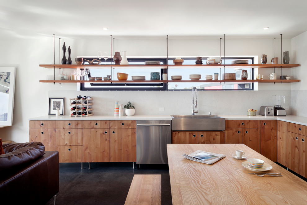 Design ideas for a mid-sized modern l-shaped open plan kitchen in Seattle with a single-bowl sink, flat-panel cabinets, light wood cabinets, quartz benchtops, white splashback, stainless steel appliances, concrete floors and no island.