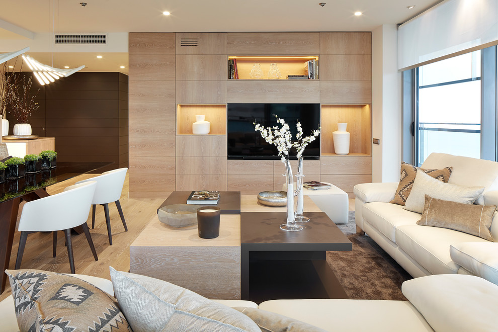 This is an example of a mid-sized contemporary formal open concept living room in Barcelona with beige walls, medium hardwood floors, no fireplace and a built-in media wall.