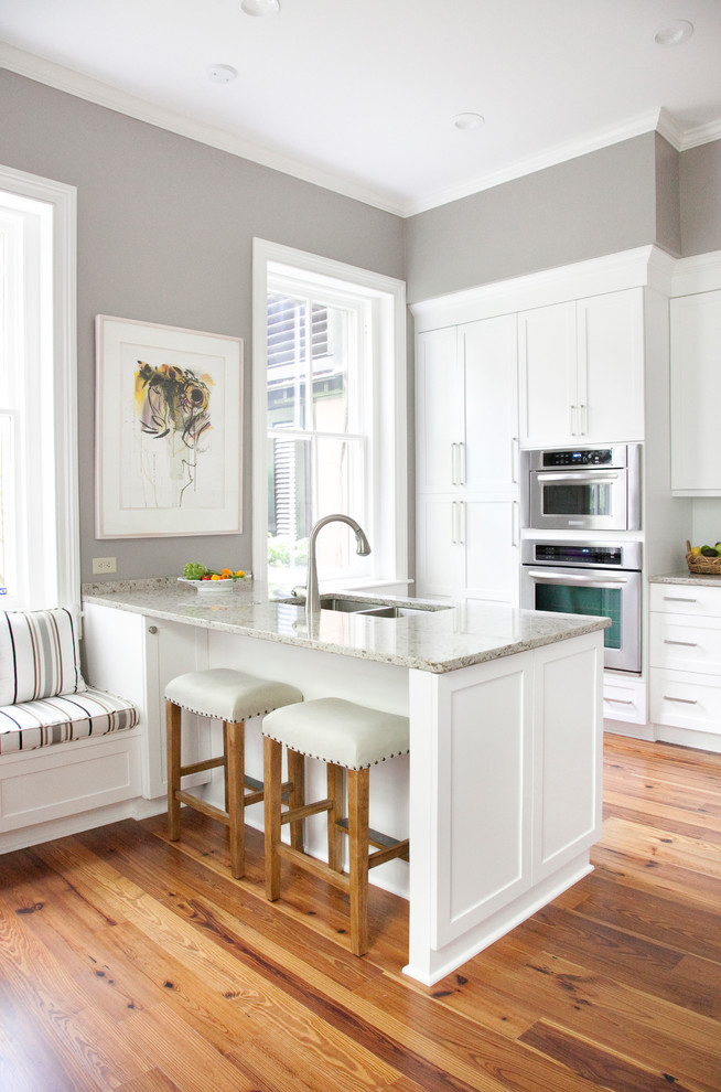 This is an example of a traditional kitchen in San Francisco with a double-bowl sink, recessed-panel cabinets, white cabinets and stainless steel appliances.