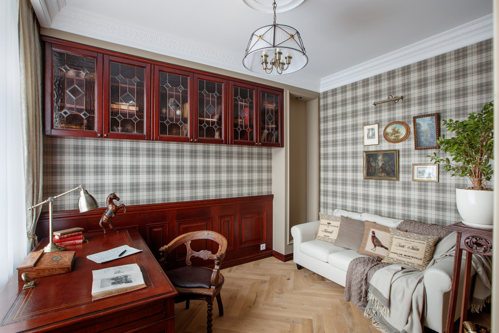 This is an example of a mid-sized traditional home office in Yekaterinburg with a library, beige walls, light hardwood floors, a freestanding desk and beige floor.