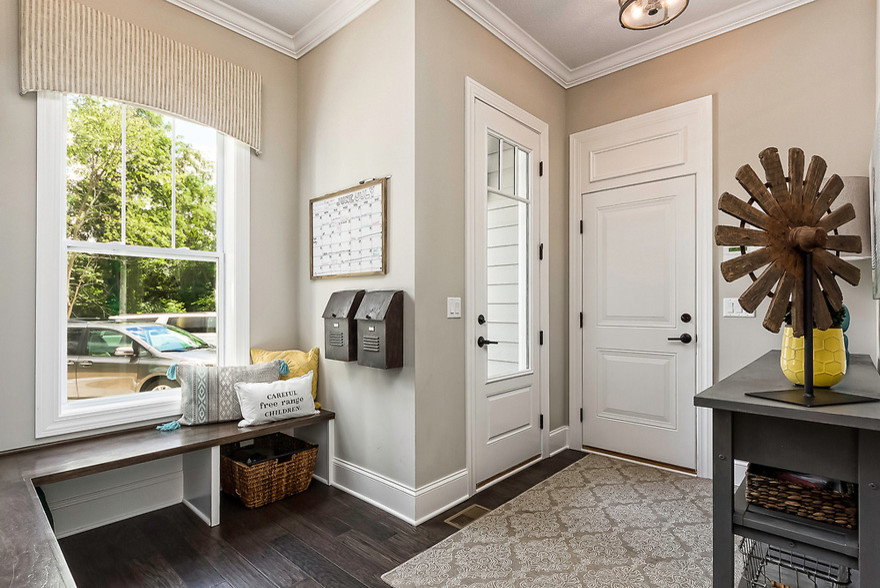 Design ideas for a mid-sized transitional mudroom in Columbus with beige walls, dark hardwood floors, a single front door, a white front door and brown floor.