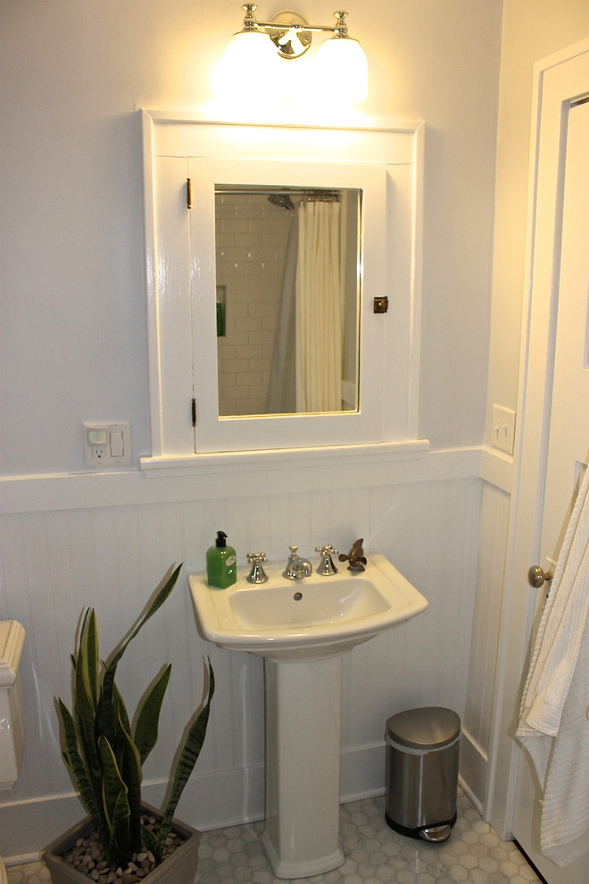Photo of a small traditional bathroom in Other with a pedestal sink, a drop-in tub, a shower/bathtub combo, a two-piece toilet, open cabinets, white cabinets, gray tile, stone tile, grey walls and marble floors.