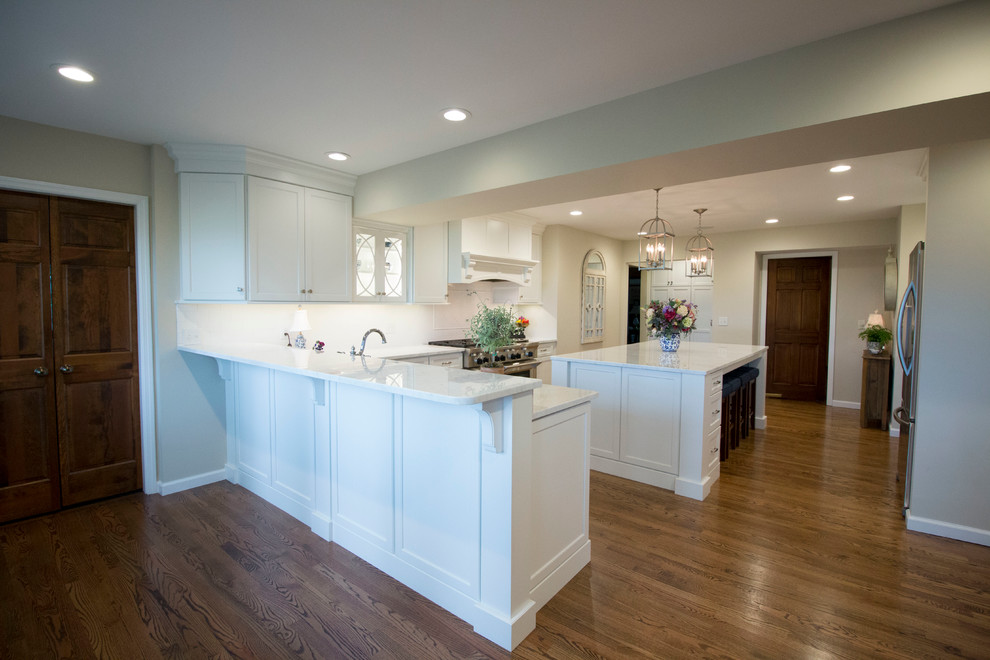 Inspiration for a huge transitional medium tone wood floor open concept kitchen remodel with an undermount sink, shaker cabinets, white cabinets, marble countertops, white backsplash, ceramic backsplash, stainless steel appliances and two islands