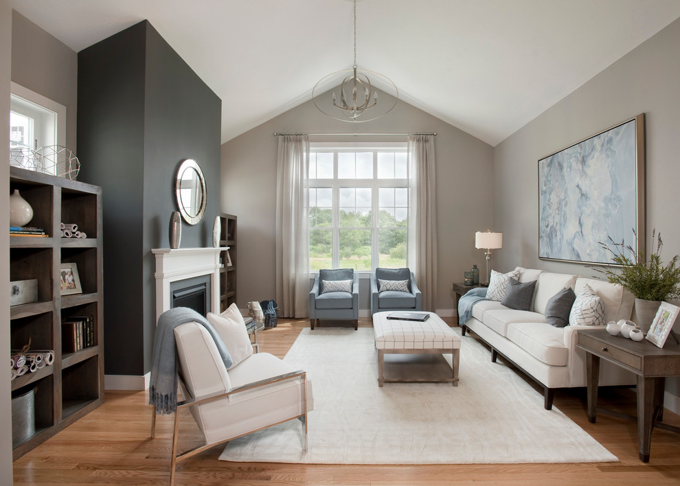 This is an example of a mid-sized transitional formal open concept living room in Boston with grey walls, light hardwood floors, a standard fireplace, a plaster fireplace surround and no tv.