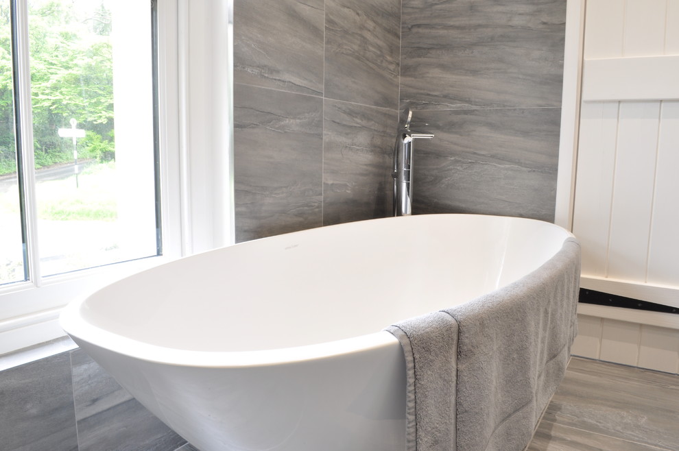 Inspiration for a small contemporary kids bathroom in Hertfordshire with grey cabinets, a freestanding tub and gray tile.