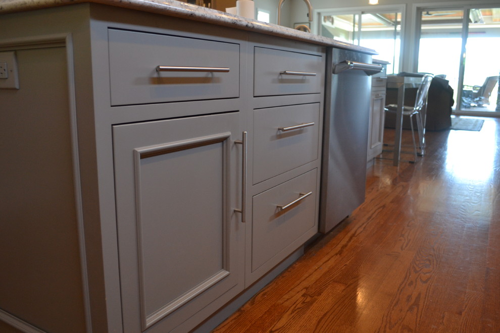 Large transitional l-shaped medium tone wood floor open concept kitchen photo in Cincinnati with an undermount sink, gray cabinets, granite countertops, multicolored backsplash, mosaic tile backsplash, stainless steel appliances, an island and beaded inset cabinets