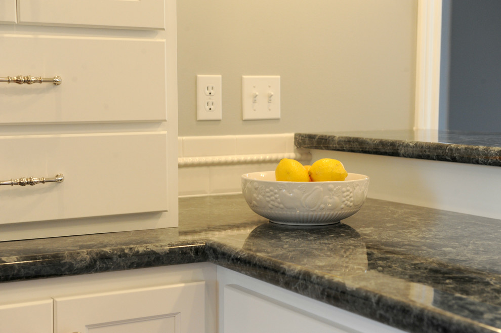 Transitional u-shaped eat-in kitchen photo in Chicago with a drop-in sink, flat-panel cabinets, white cabinets, laminate countertops, white backsplash and subway tile backsplash